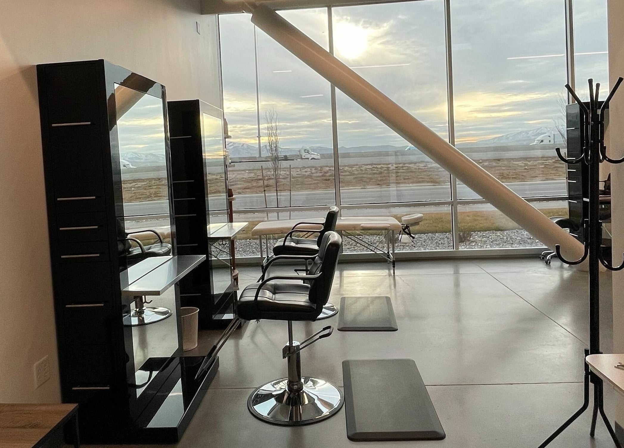 Modern interior of Weave Salon in Lehi, Utah, US with stylish chairs and large windows showing a scenic view.