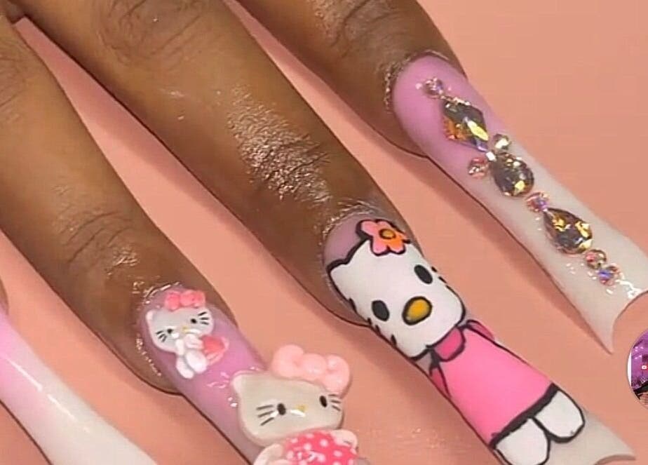 Detailed Hello Kitty nail art by Nailzbyari in Columbus, Ohio, US. Pink and white designs with 3D elements.