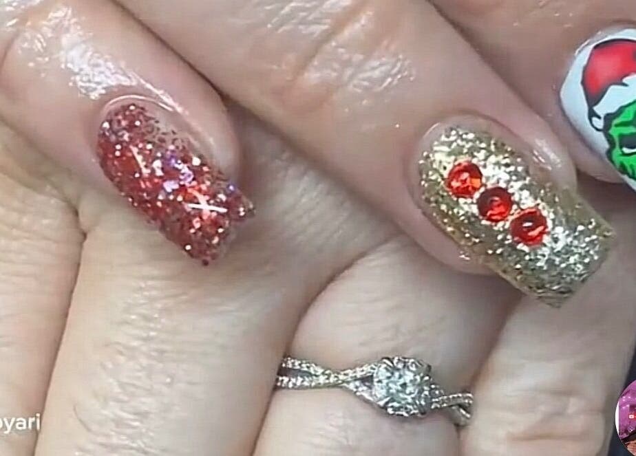 Festive glitter nail art with Grinch design at Nailzbyari, Columbus, Ohio, US.