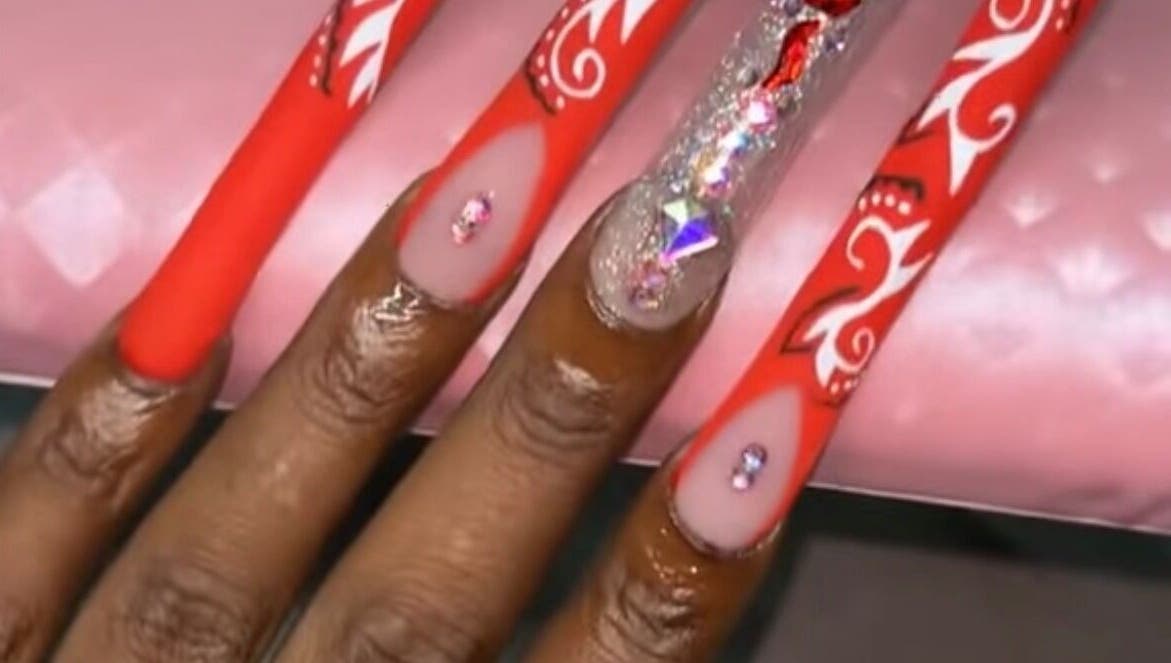 Stylish red nails with rhinestone accents at Nailzbyari, Columbus, Ohio, US.