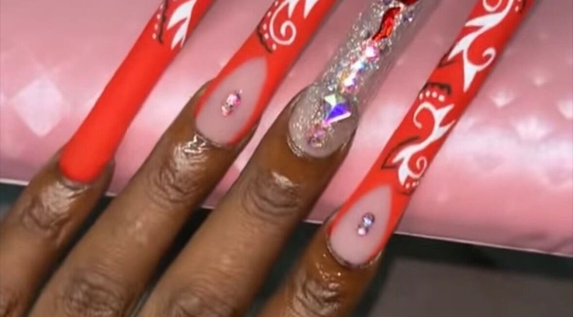 Stylish red nails with rhinestone accents at Nailzbyari, Columbus, Ohio, US.