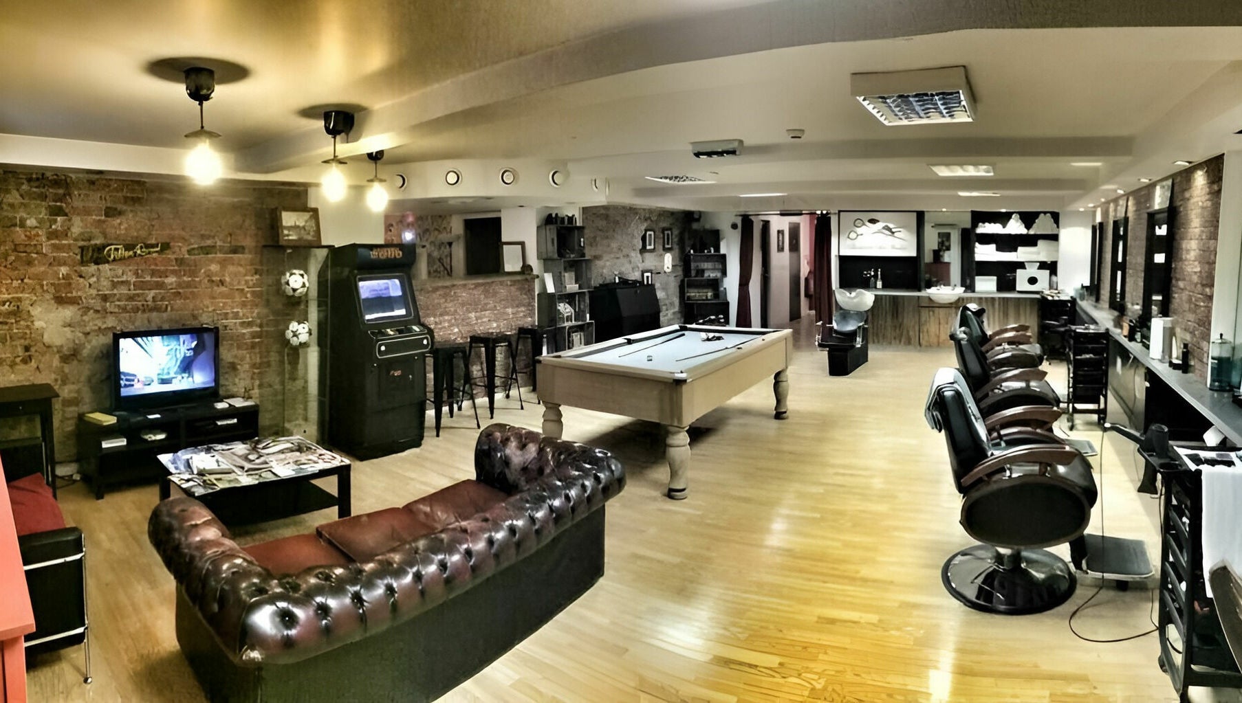 Interior of Basement 68 Barbers in Leeds, England, GB, featuring a stylish setup with barber chairs and a pool table.