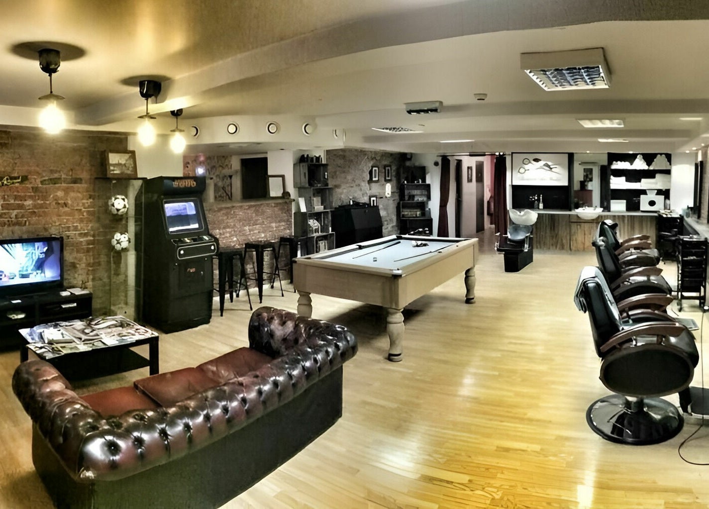 Interior of Basement 68 Barbers in Leeds, England, GB, featuring a stylish setup with barber chairs and a pool table.