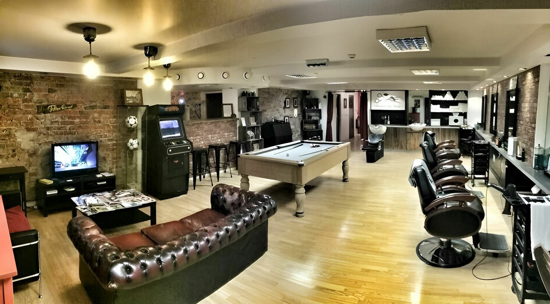 Interior of Basement 68 Barbers in Leeds, England, GB, featuring a stylish setup with barber chairs and a pool table.