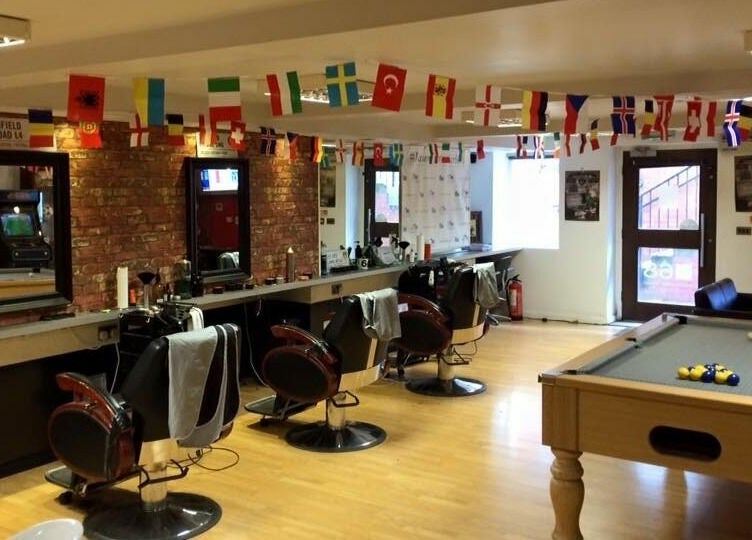 Spacious interior of Basement 68 Barbers, featuring barber chairs and pool table in Leeds, England, GB.