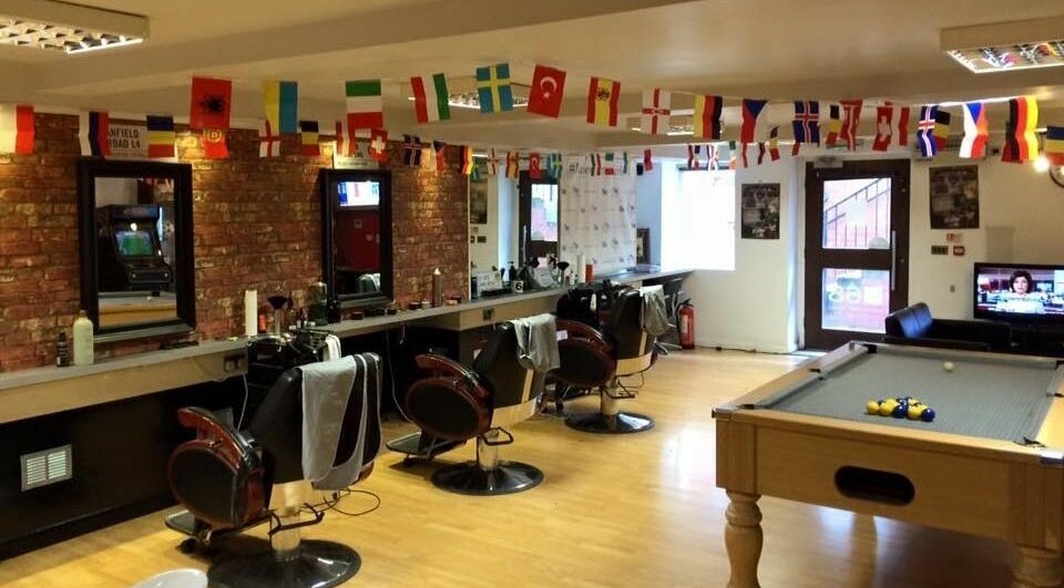 Spacious interior of Basement 68 Barbers, featuring barber chairs and pool table in Leeds, England, GB.