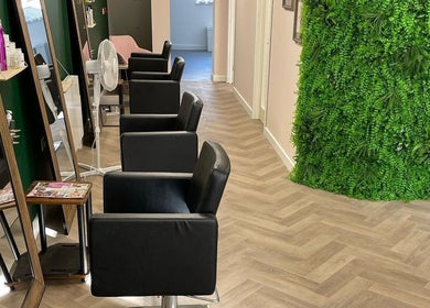 Modern salon interior at The Beauty Hut Pontyclun, Pontyclun, Wales, GB with sleek chairs and lush greenery.