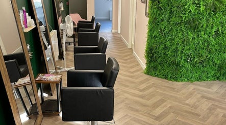 Modern salon interior at The Beauty Hut Pontyclun, Pontyclun, Wales, GB with sleek chairs and lush greenery.