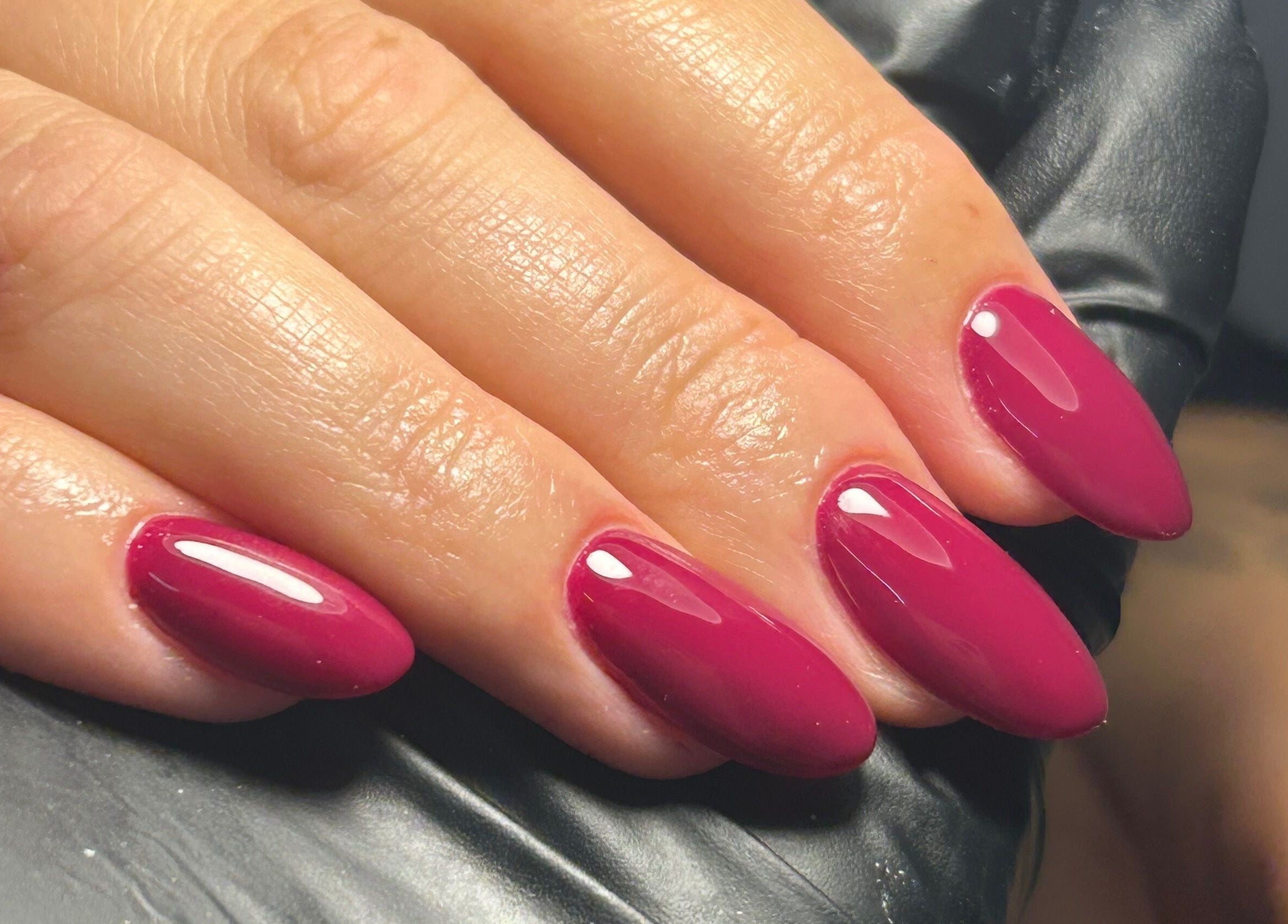 Close-up of glossy fuchsia nails at Shanice Marie Beauty, Taunton, England, GB.