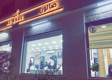واجهة صالون الخال المضيئة في الليل بعمّان, محافظة العاصمة, JO تعرض تصميم داخلي حديث.
