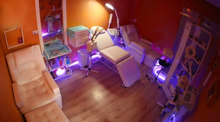 صالون الخال في شارع عبدالله غوشة، عمان. غرفة تجميل مريحة مع كراسي بيضاء وأضواء بنفسجية.