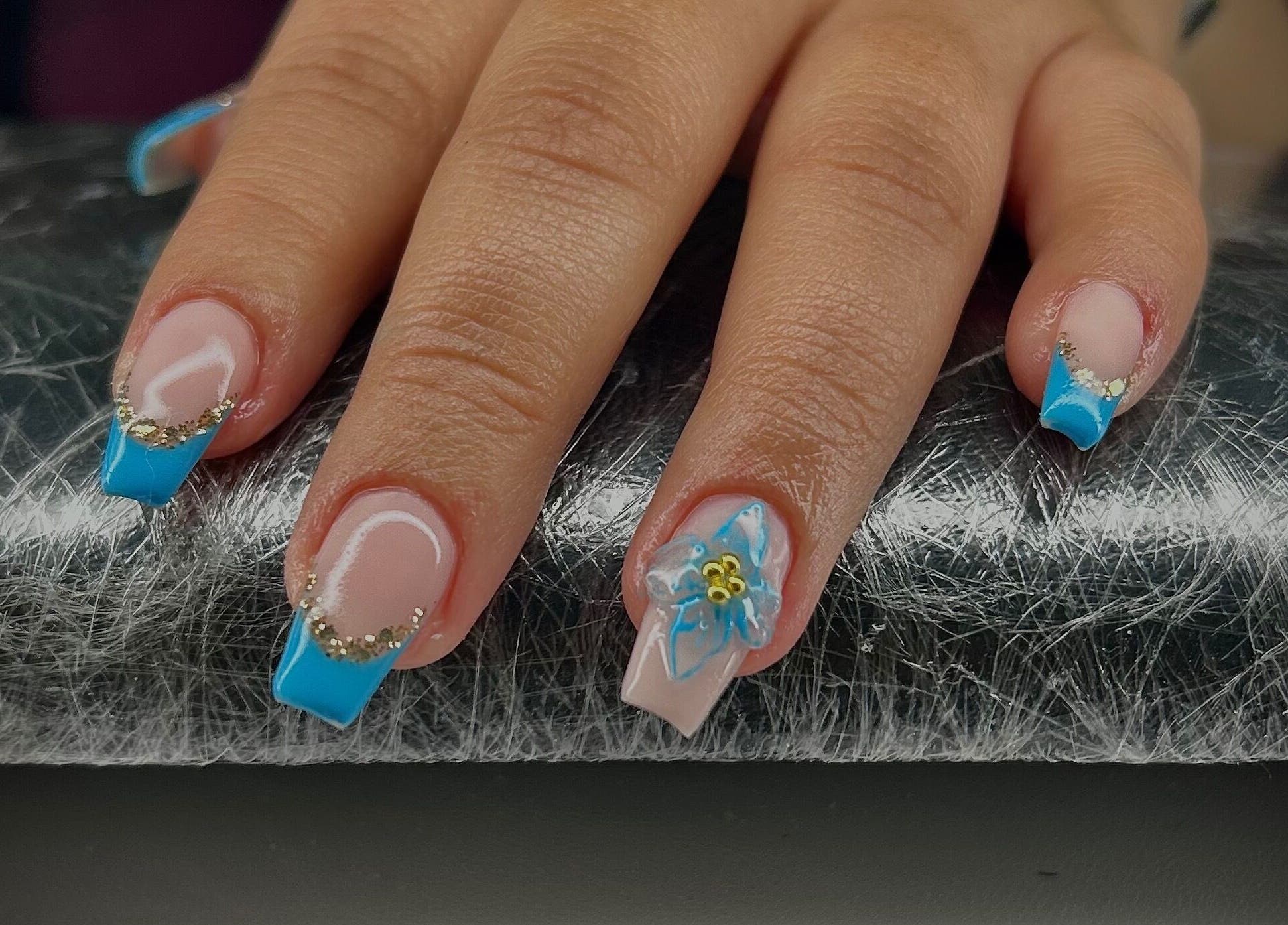 Elegant blue manicure with floral design at Pure Nail Care & Waxing, Cape Town, Western Cape, ZA.