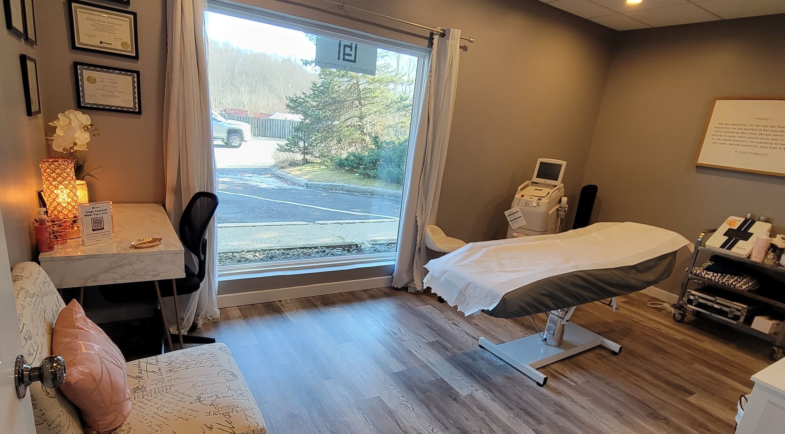 Cozy treatment room at Elemental Aesthetics, Mahopac, New York, US with a bed and large window view.