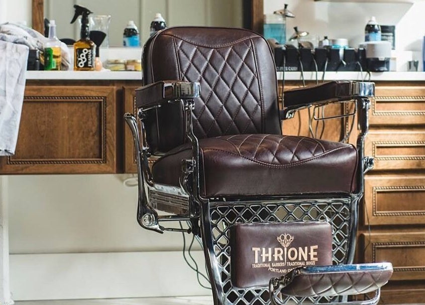 Elegant barber chair at Throne Traditional Barbershop on Williams, Portland, Oregon, US with vintage wood decor.