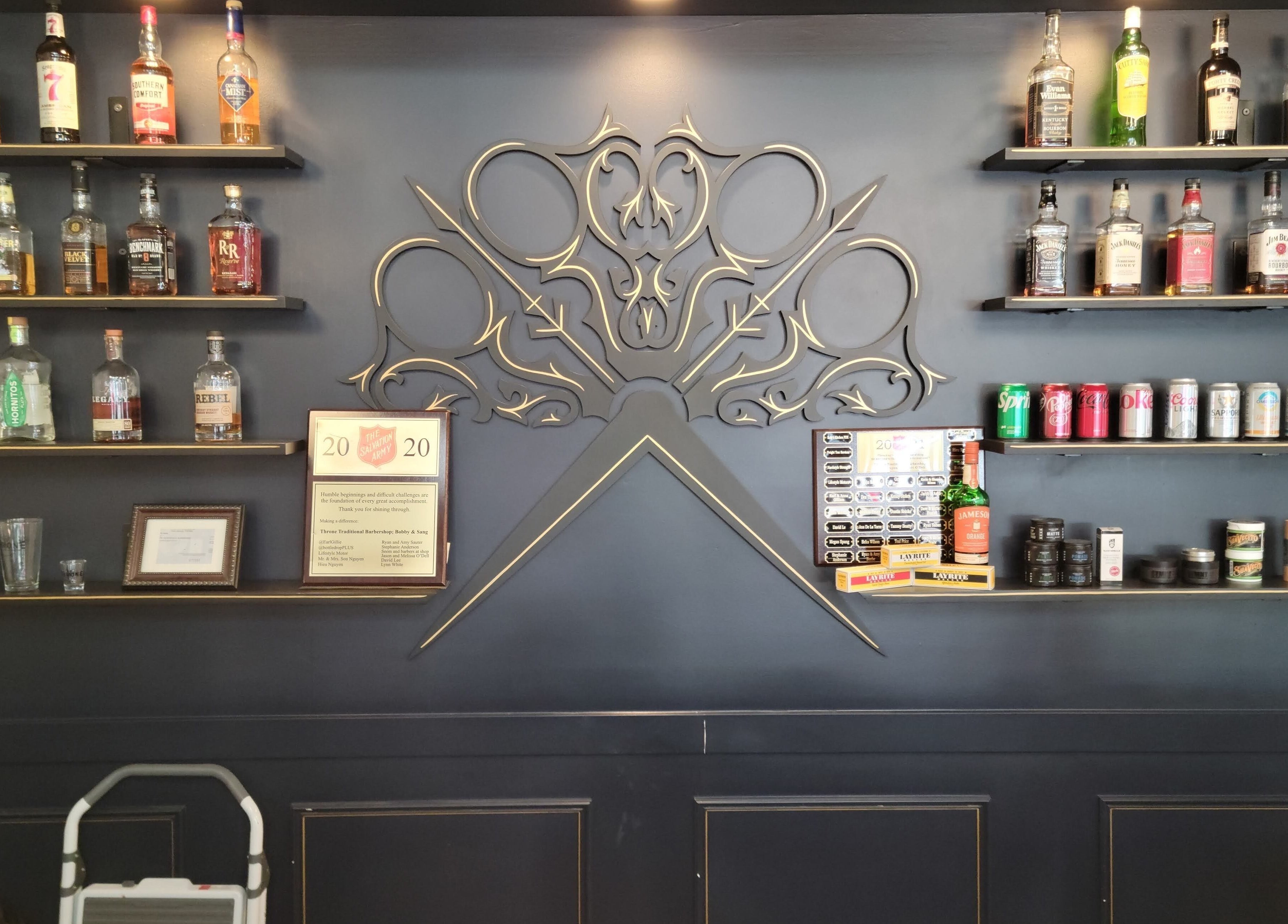 Decorative shelves with bottles and products at Throne Traditional Barbershop on Williams, Portland, Oregon, US.