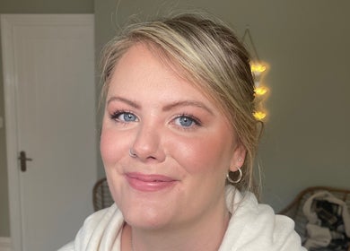Smiling woman with glowing skin at Lara Kingshott Beauty, Bedford, England, GB.