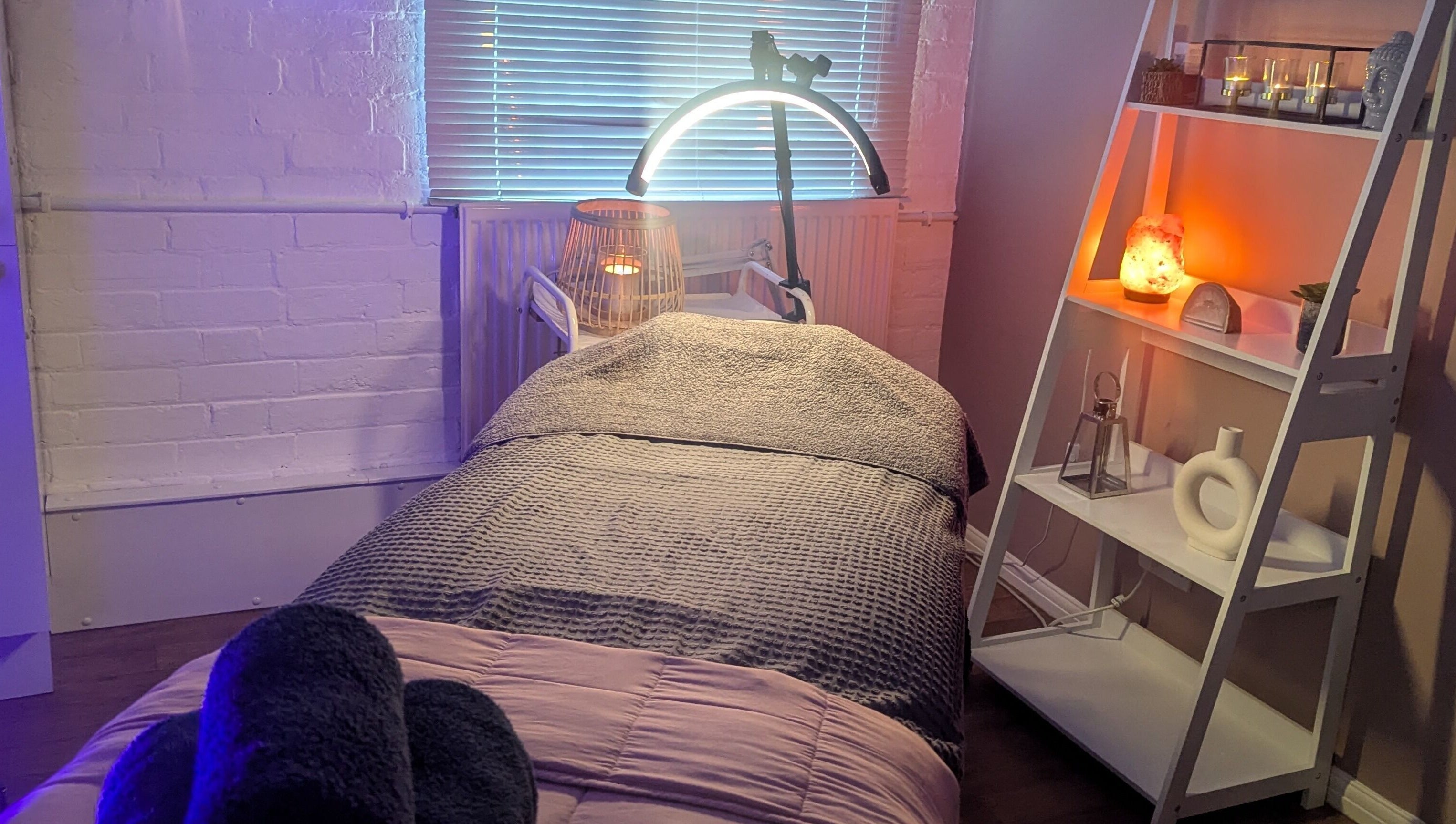Cozy treatment room at Eloquin in Basingstoke, England, GB, featuring ambient lighting and a relaxing bed.