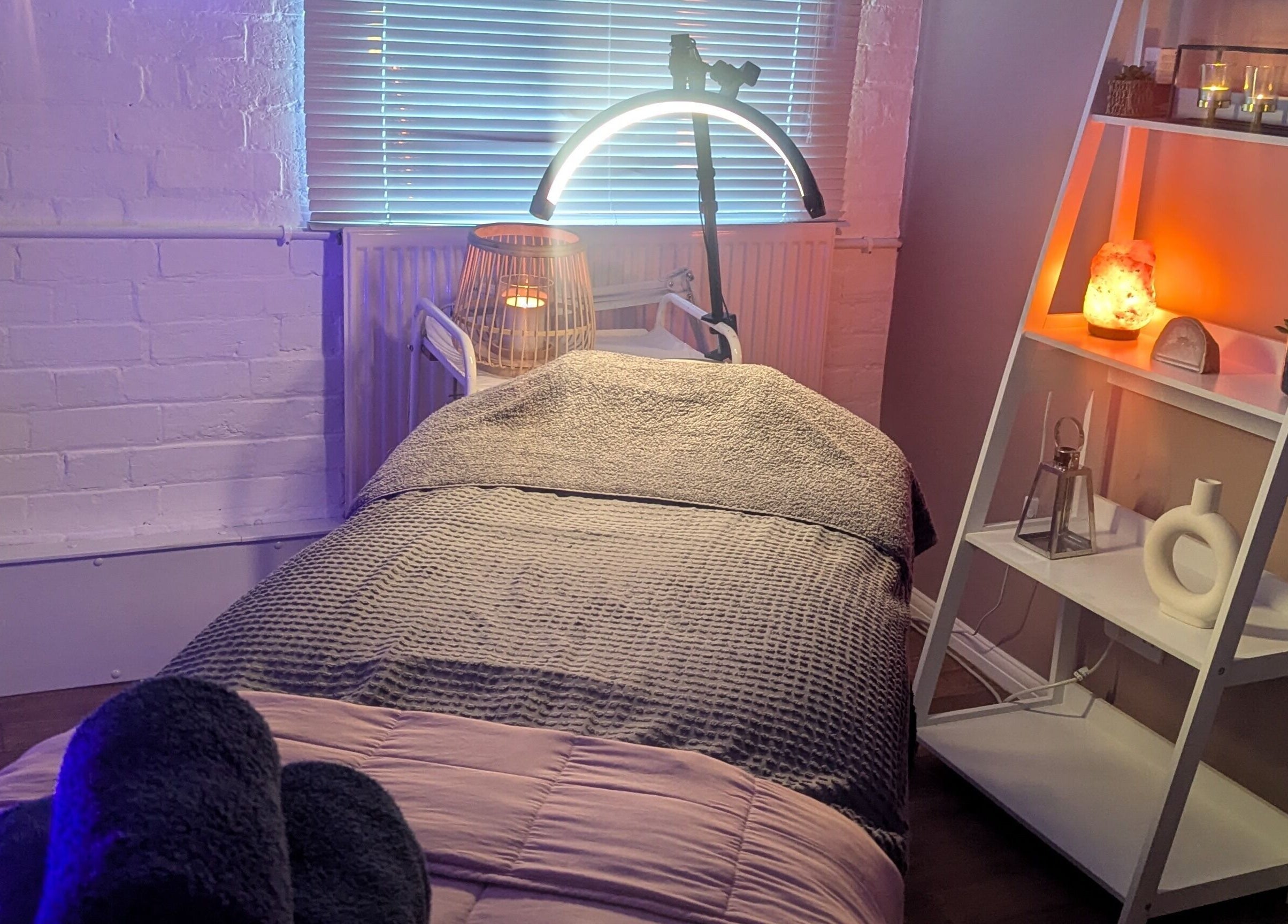Cozy treatment room at Eloquin in Basingstoke, England, GB, featuring ambient lighting and a relaxing bed.