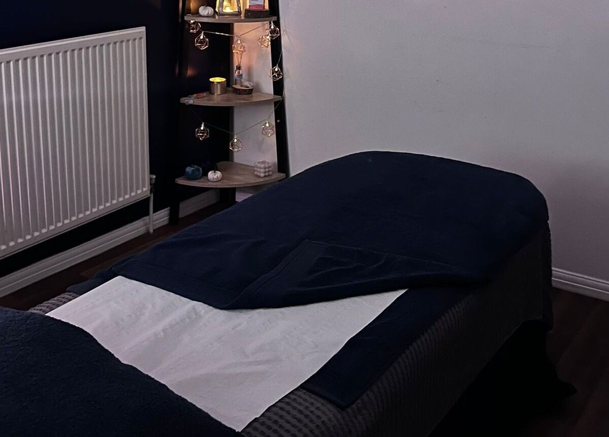 Cozy treatment room at Eloquin, Basingstoke, England, GB, with warm lighting and inviting massage table.