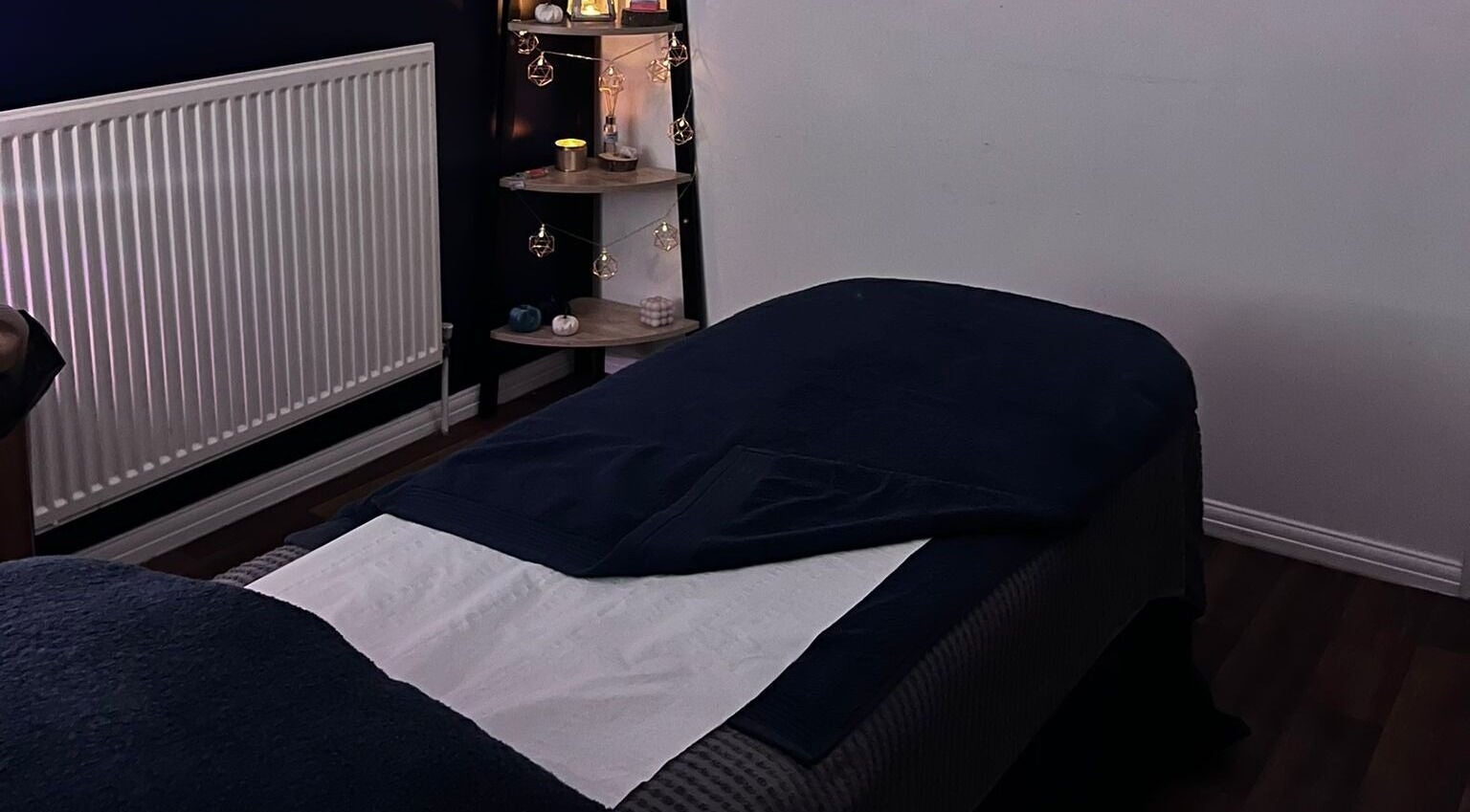 Cozy treatment room at Eloquin, Basingstoke, England, GB, with warm lighting and inviting massage table.