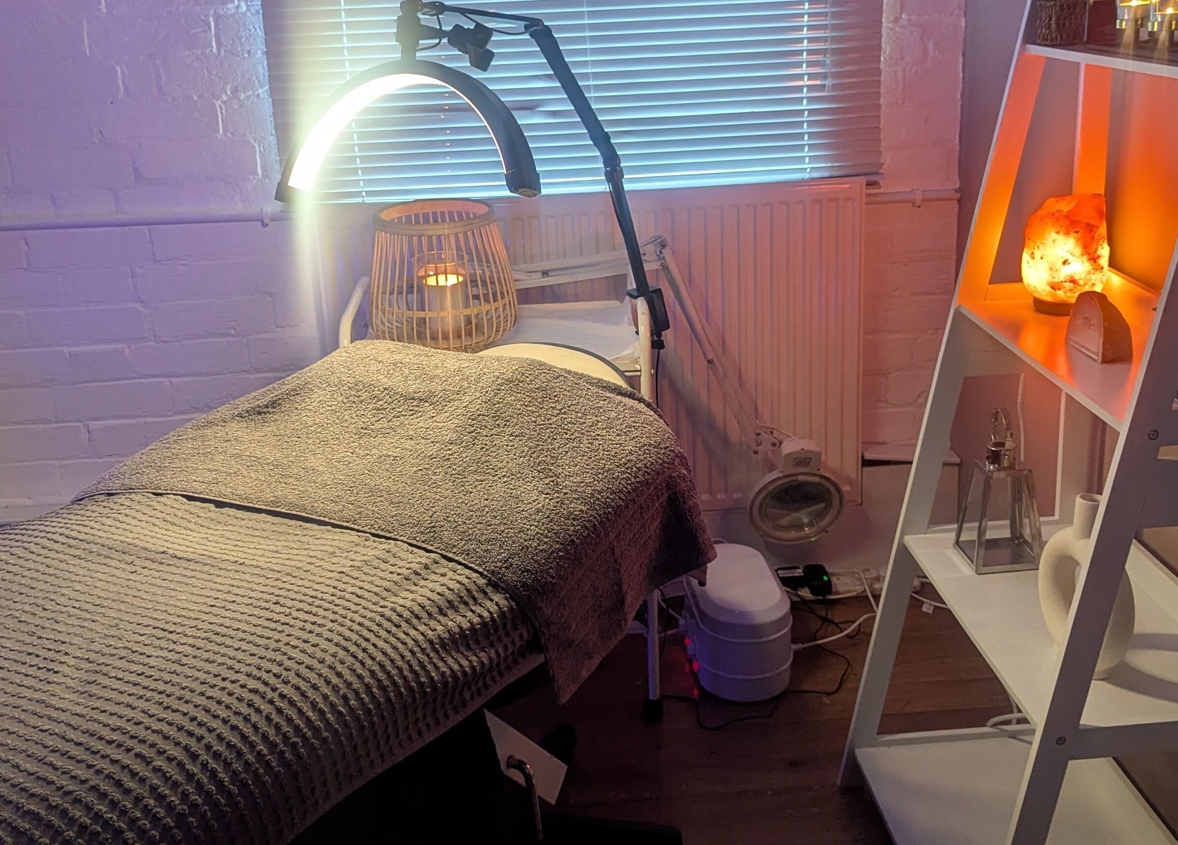 Relaxing treatment room at Eloquin, Basingstoke, England, GB with soft lighting and cozy décor.