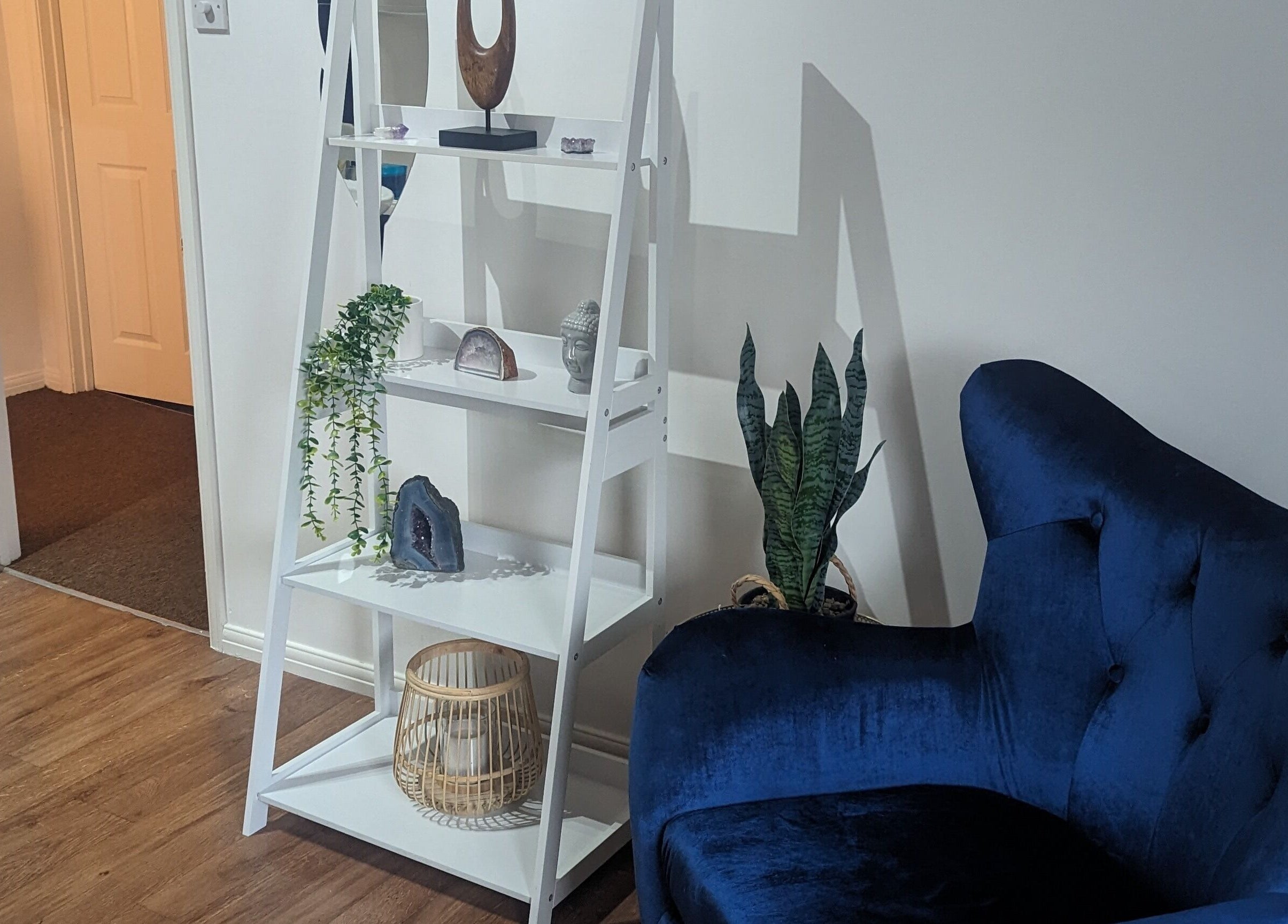 Inviting decor at Eloquin in Basingstoke, England, GB with a blue velvet chair and elegant shelving.