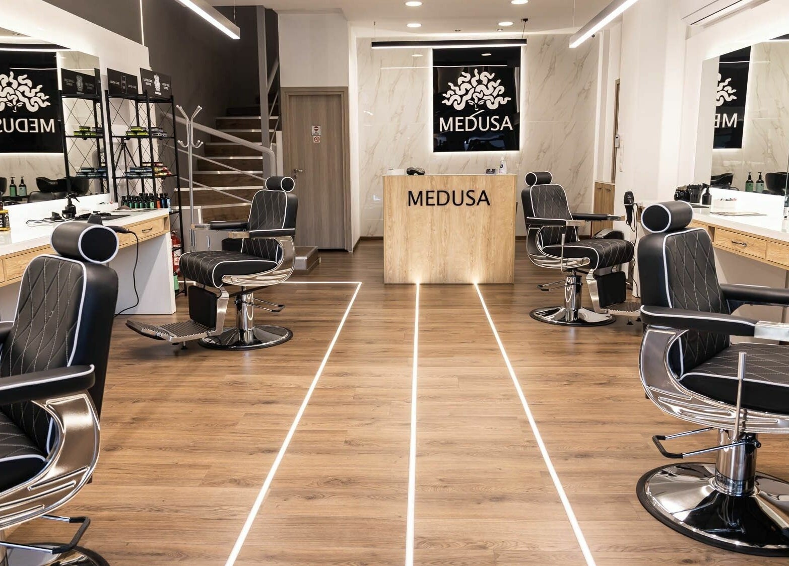 Εσωτερικό του κομμωτηρίου Medusa Barber στη Θεσσαλονίκη, GR με κομψές καρέκλες και καθρέφτες.