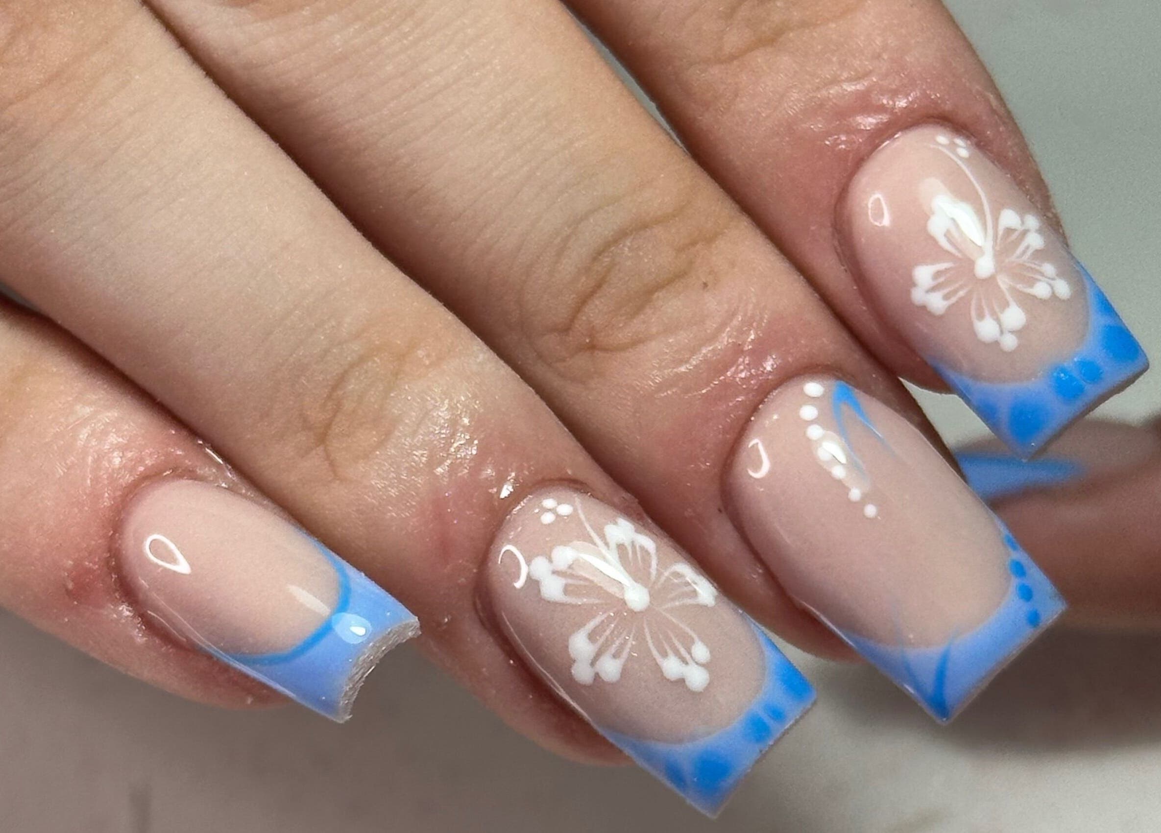Floral nail art with blue tips by LKR Beauty in Wigan, England, GB, showcasing elegant design and artistry.