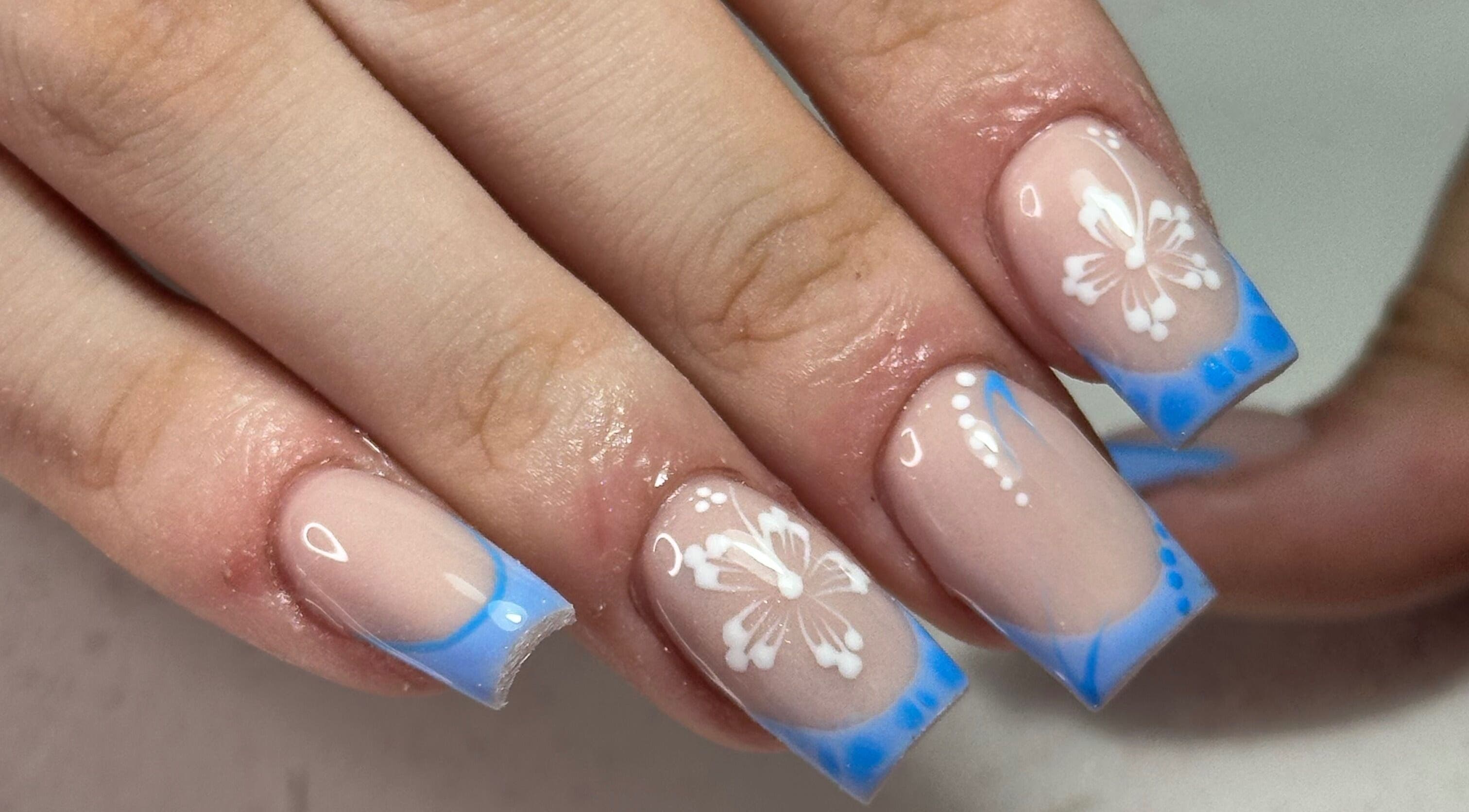 Floral nail art with blue tips by LKR Beauty in Wigan, England, GB, showcasing elegant design and artistry.