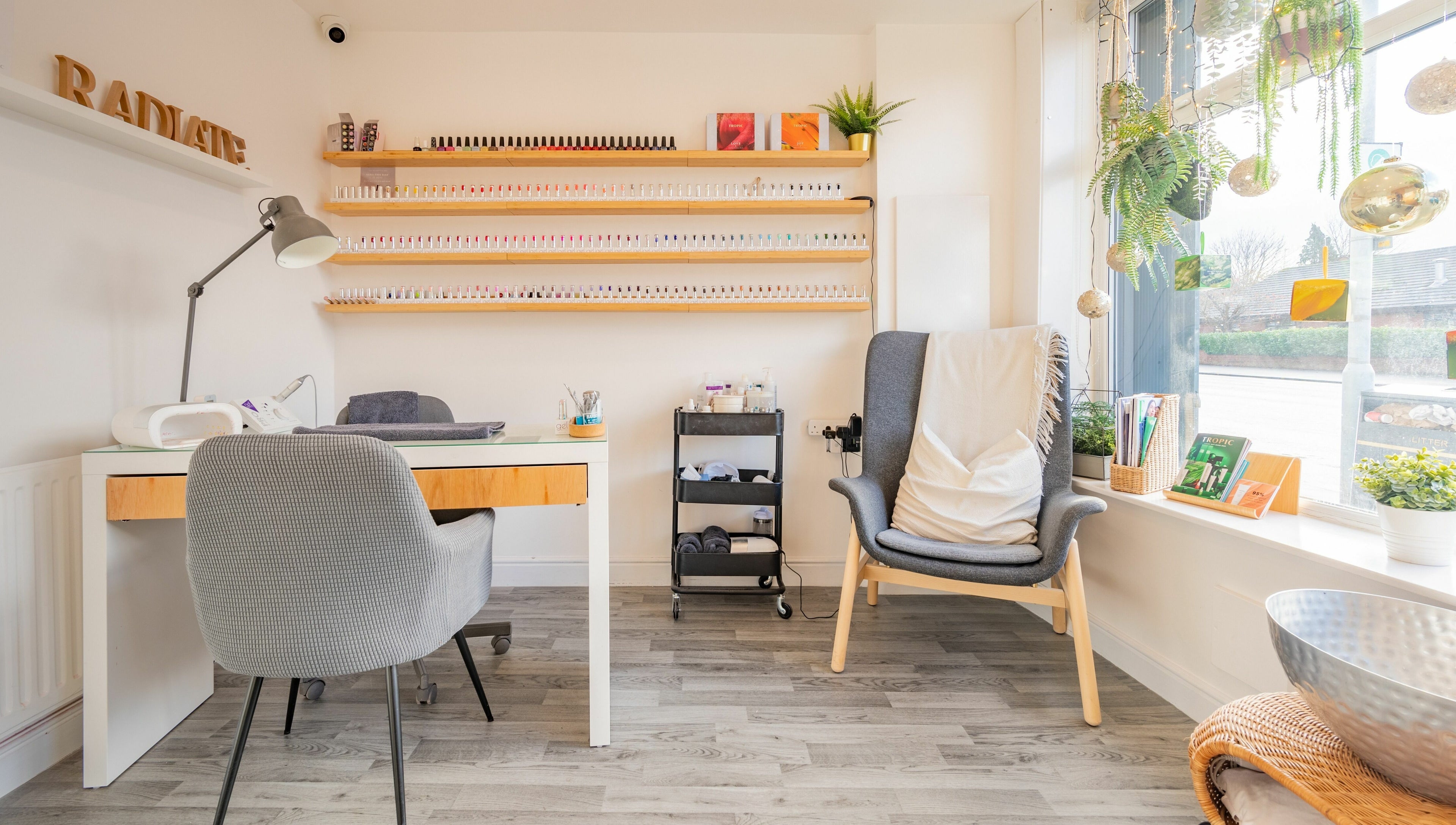 Cozy nail studio at Radiate Health and Beauty, Stockport, England, GB with nail polish display and comfy seating.
