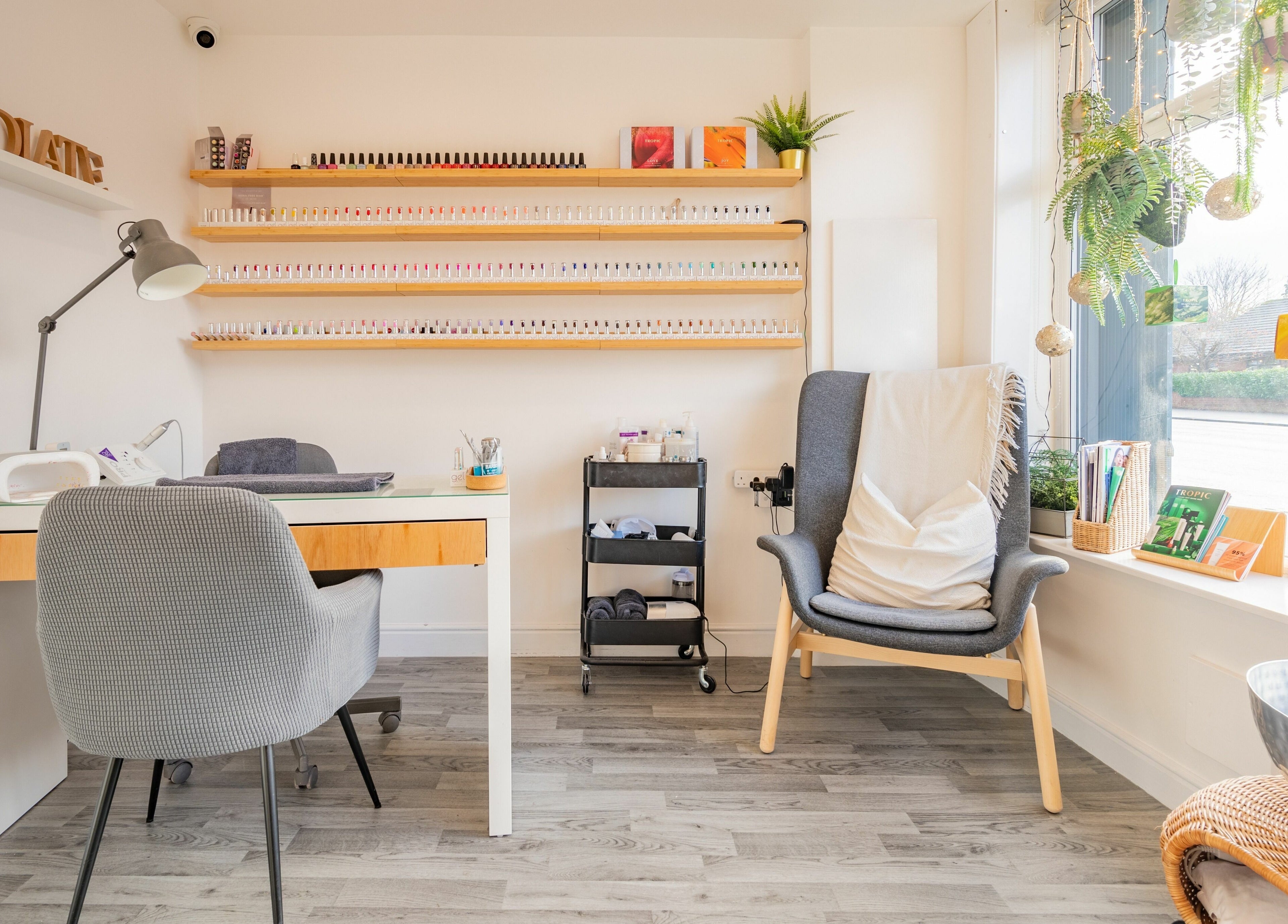 Cozy nail studio at Radiate Health and Beauty, Stockport, England, GB with nail polish display and comfy seating.