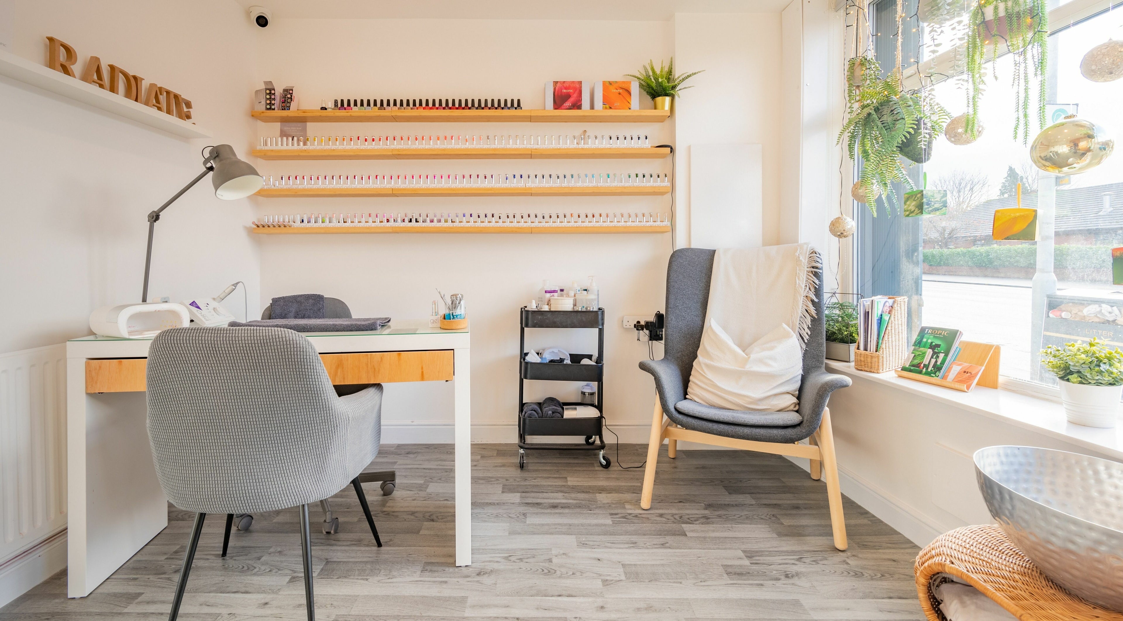 Cozy nail studio at Radiate Health and Beauty, Stockport, England, GB with nail polish display and comfy seating.