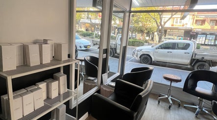 Inside Hair Artistry Studio in Camden, New South Wales, AU, showcasing modern chairs and hair products by the window.