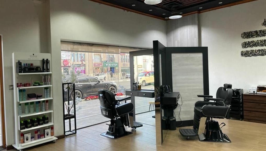 Stylish barbershop interior at Brothers Salon and Spa, Dubai, AE with black chairs and product display.