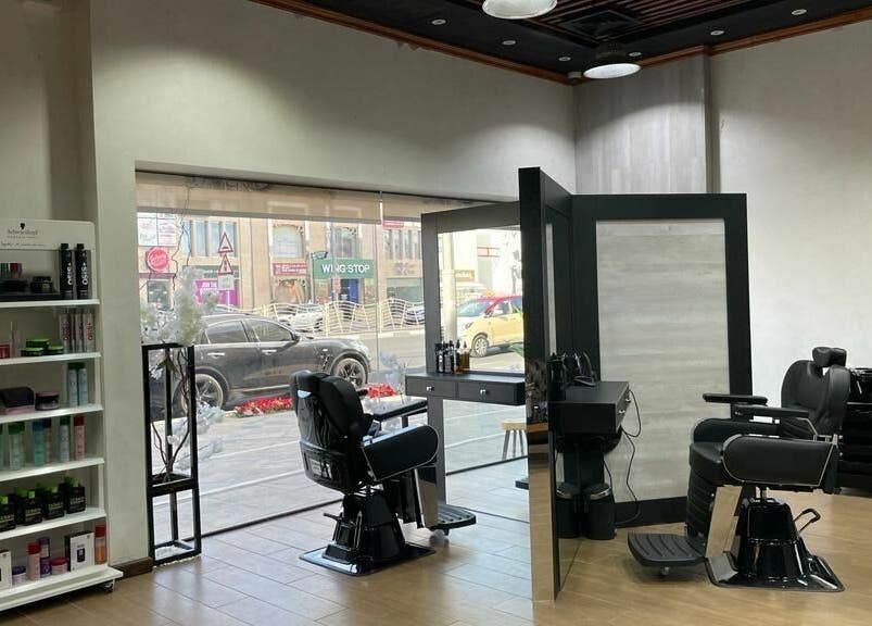 Stylish barbershop interior at Brothers Salon and Spa, Dubai, AE with black chairs and product display.