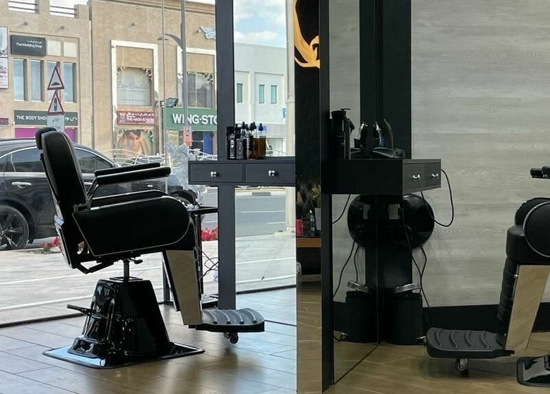 Modern barber chair at Brothers Salon and Spa, Dubai, AE, overlooking a busy street through a large window.