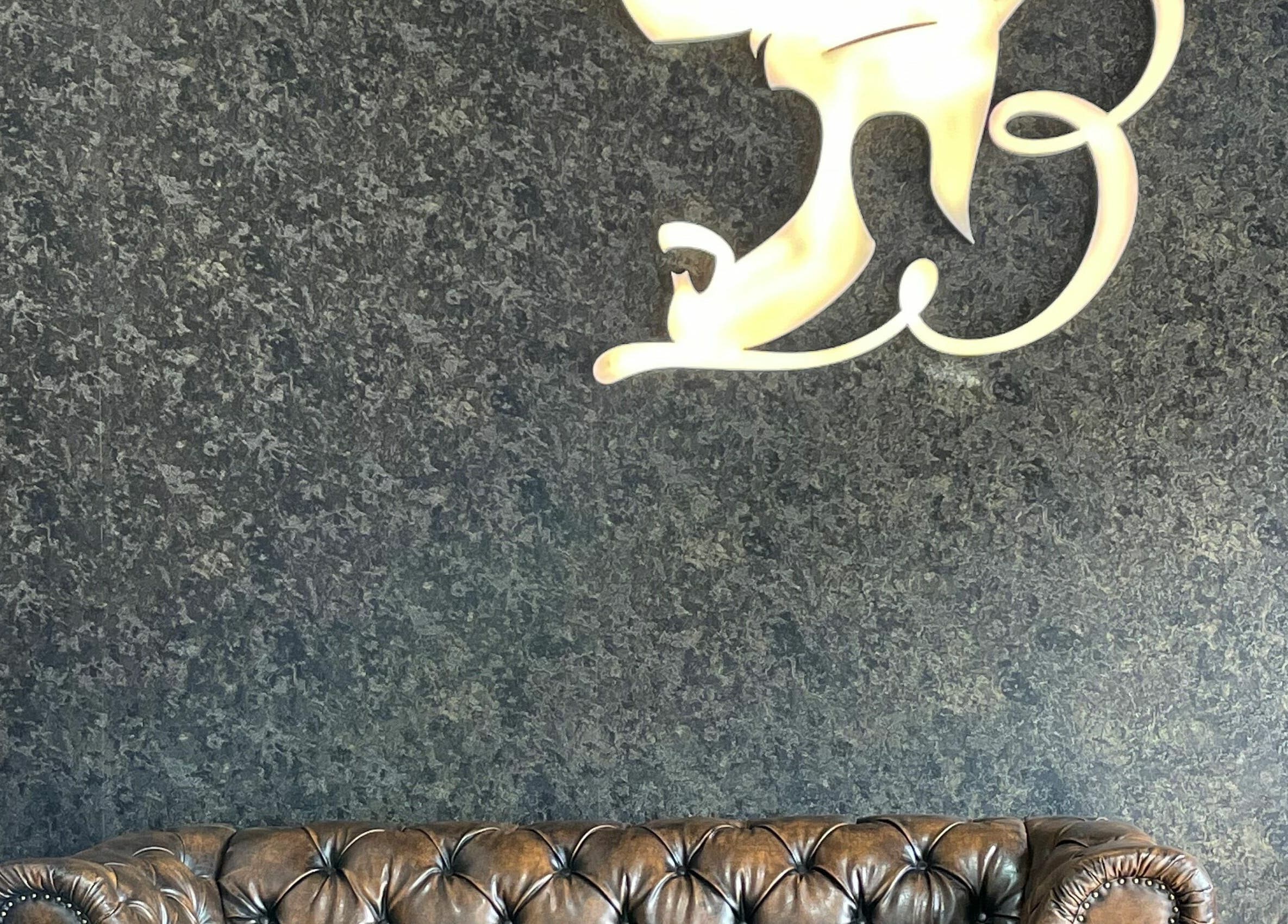 Leather sofa with artistic wall decor at Brothers Salon and Spa, Dubai, AE, offering luxurious relaxation.