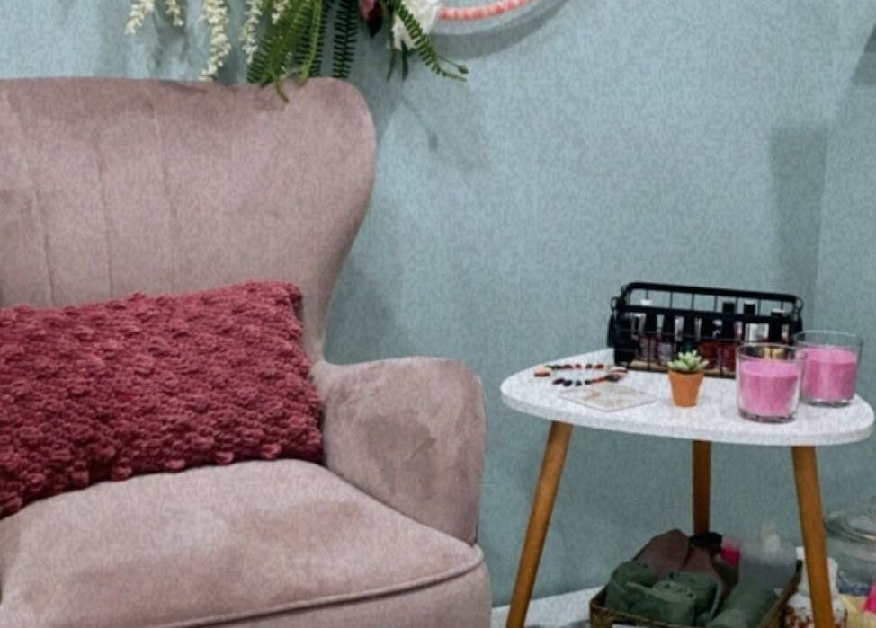 Άνετη γωνιά στο Κυμοθόη beauty lab Ερέτρια, Ερέτρια, GR με κομψή πολυθρόνα και διακοσμητικά κεριά.