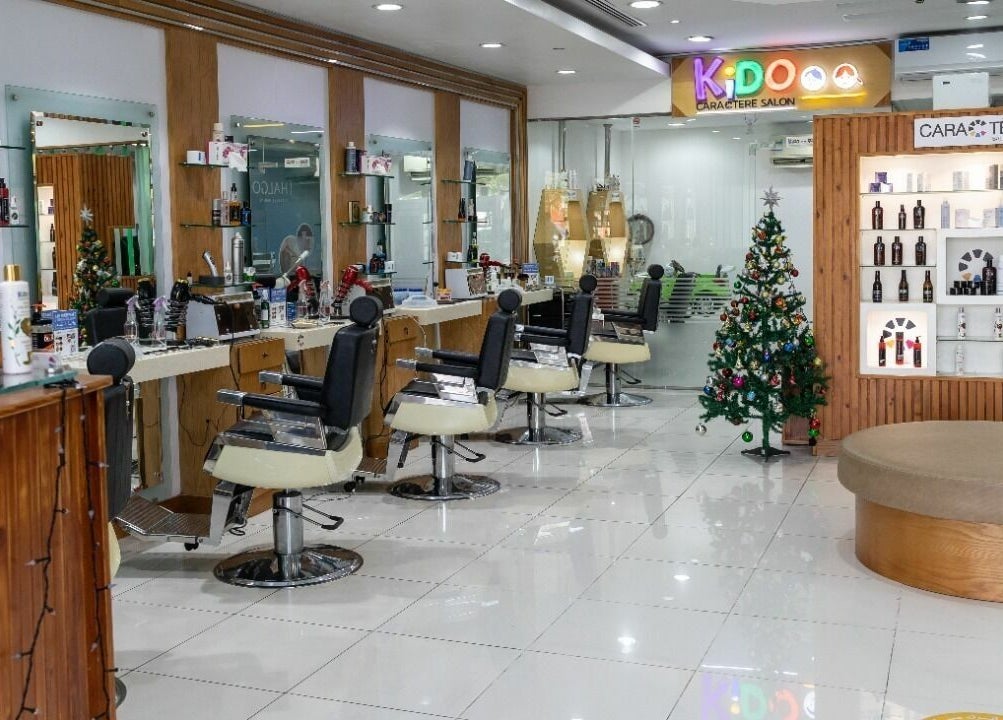 Chic interior of Caractere Salon -كاريكتير - Motor City in Dubai, AE with stylist chairs and product display.