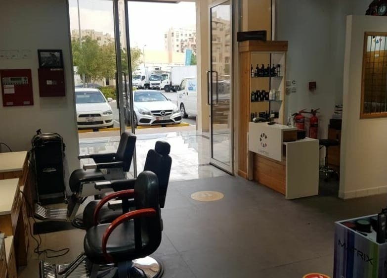 Interior view of Caractere Remraam Gents in Dubai, AE, featuring styling chairs and entrance.