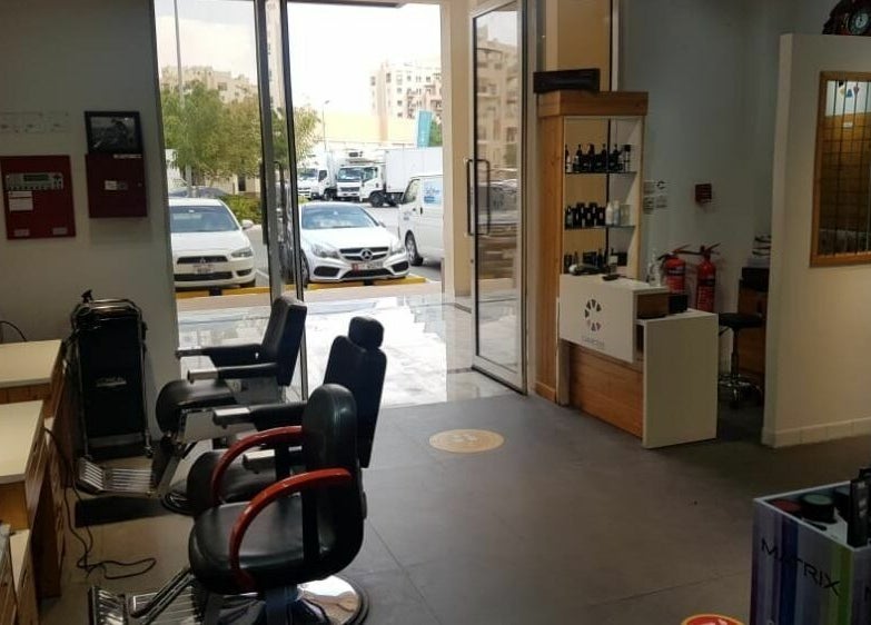 Interior view of Caractere Remraam Gents in Dubai, AE, featuring styling chairs and entrance.