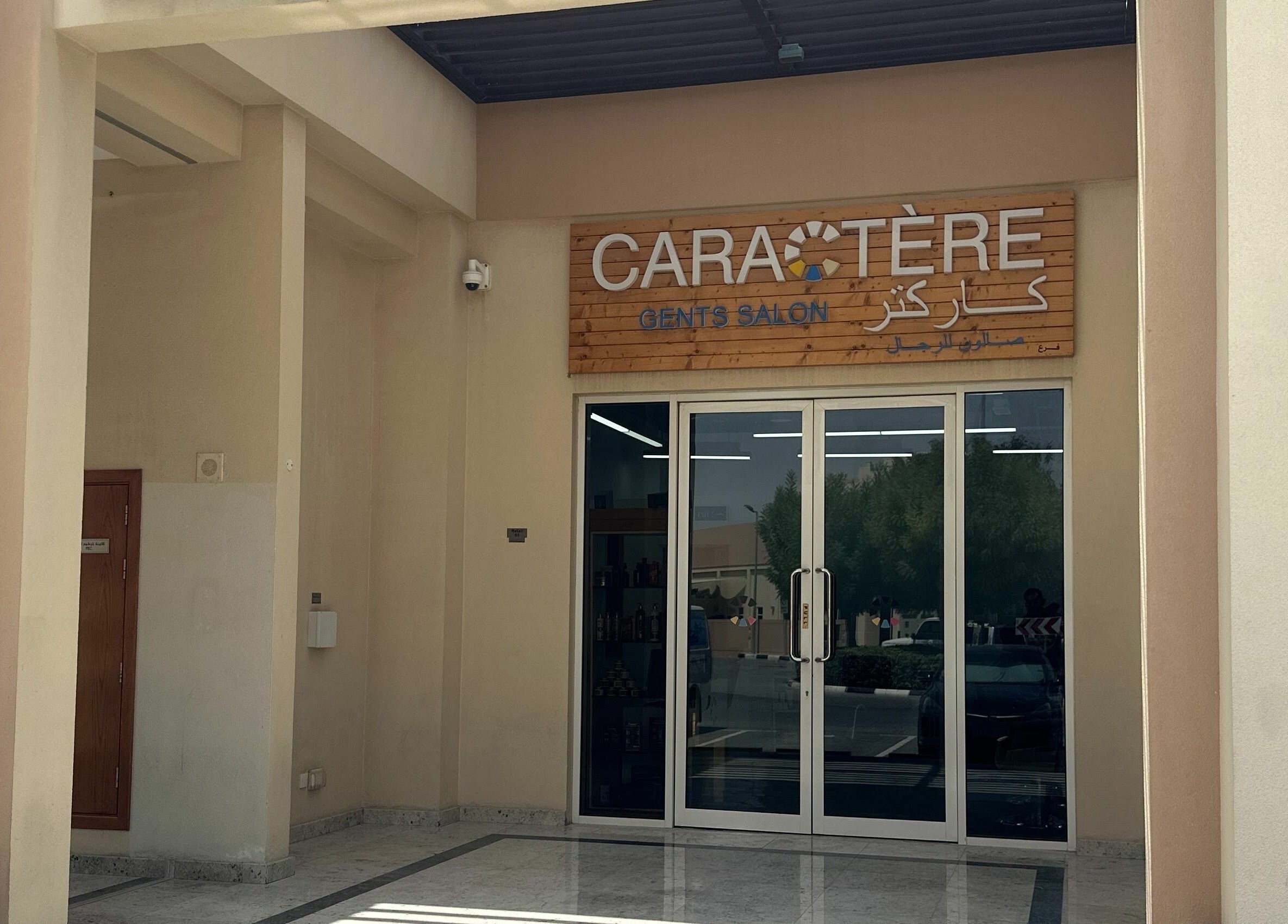 Caractere Remraam Gents salon entrance in Dubai, AE with sleek glass doors and signage.