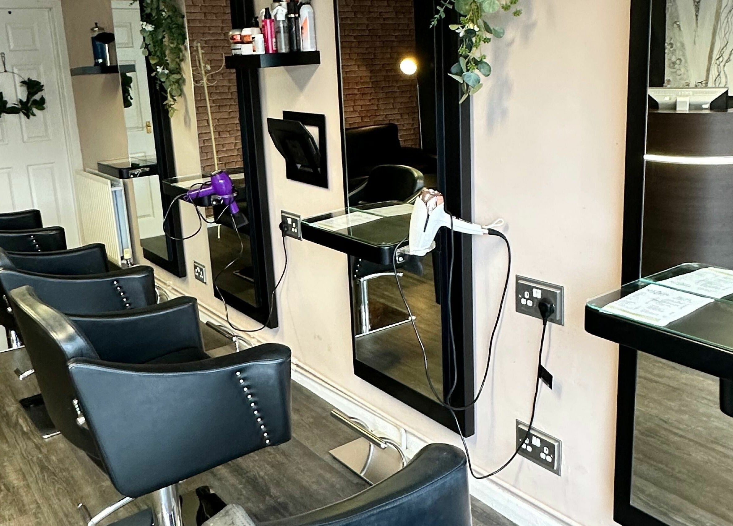 Luxurious styling chairs at Xclusive Hair, Bournemouth, England, GB. Modern salon interior with mirrors.
