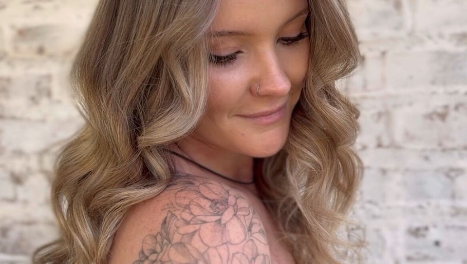 Close-up of a woman with wavy hair and floral tattoo at Cai The Stylist, Benoni, Gauteng, ZA.