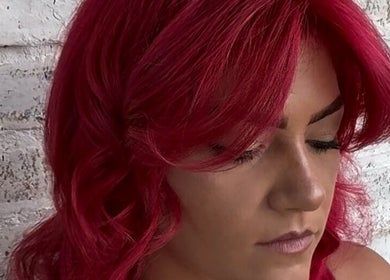 Vibrant red hairstyle created by Cai The Stylist in Benoni, Gauteng, ZA, showcasing expert coloring techniques.
