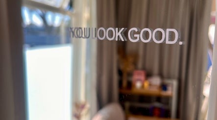 Mirror with 'You Look Good' text at Enhanced Beauty, Westport, West Coast, NZ reflecting a cozy room.