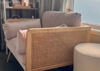 Cozy lounge area at Enhanced Beauty, Westport, West Coast, NZ with plush seating by a sunlit window.
