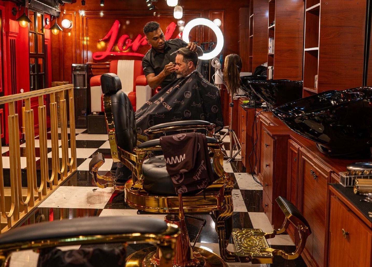 Interior de Barberia Lords ®️ VIP C.C. Unicentro en Bogotá: barbero atendiendo a cliente en silla estilizada.