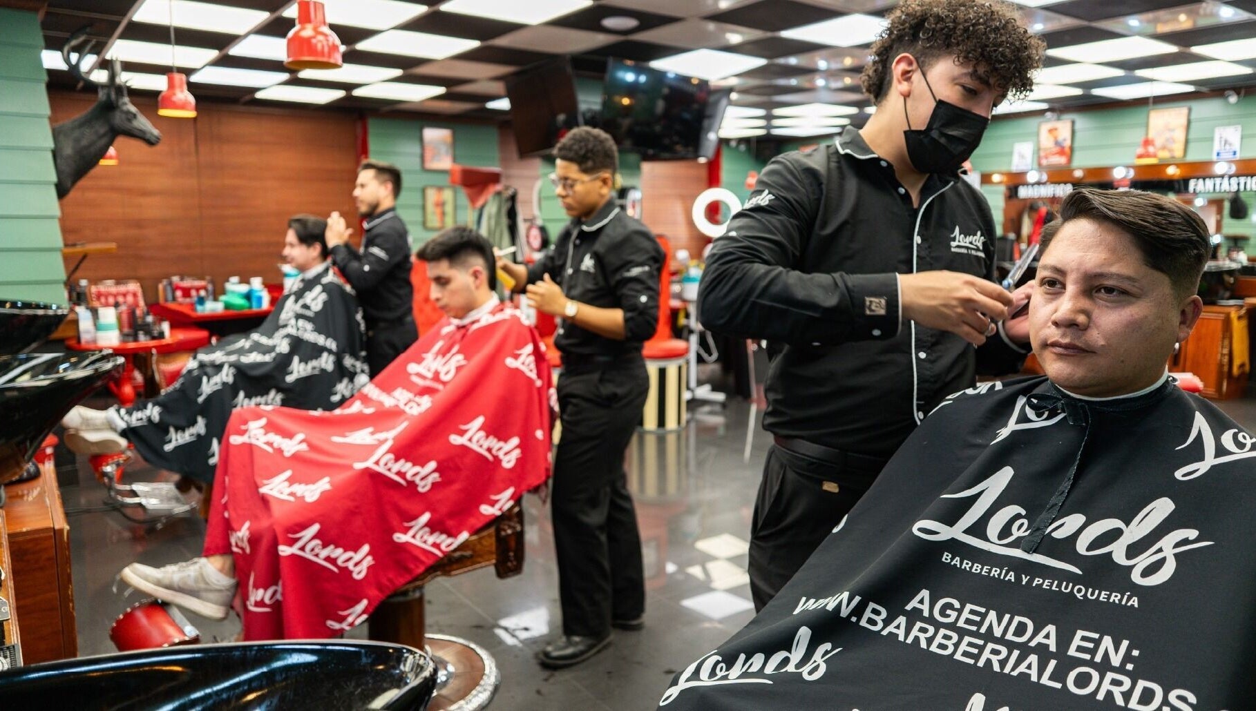 Servicio de barbero en Barberia Lords Sucursal Country Club, Bogotá, Bogotá, CO. Clientes relajados recibiendo cortes.