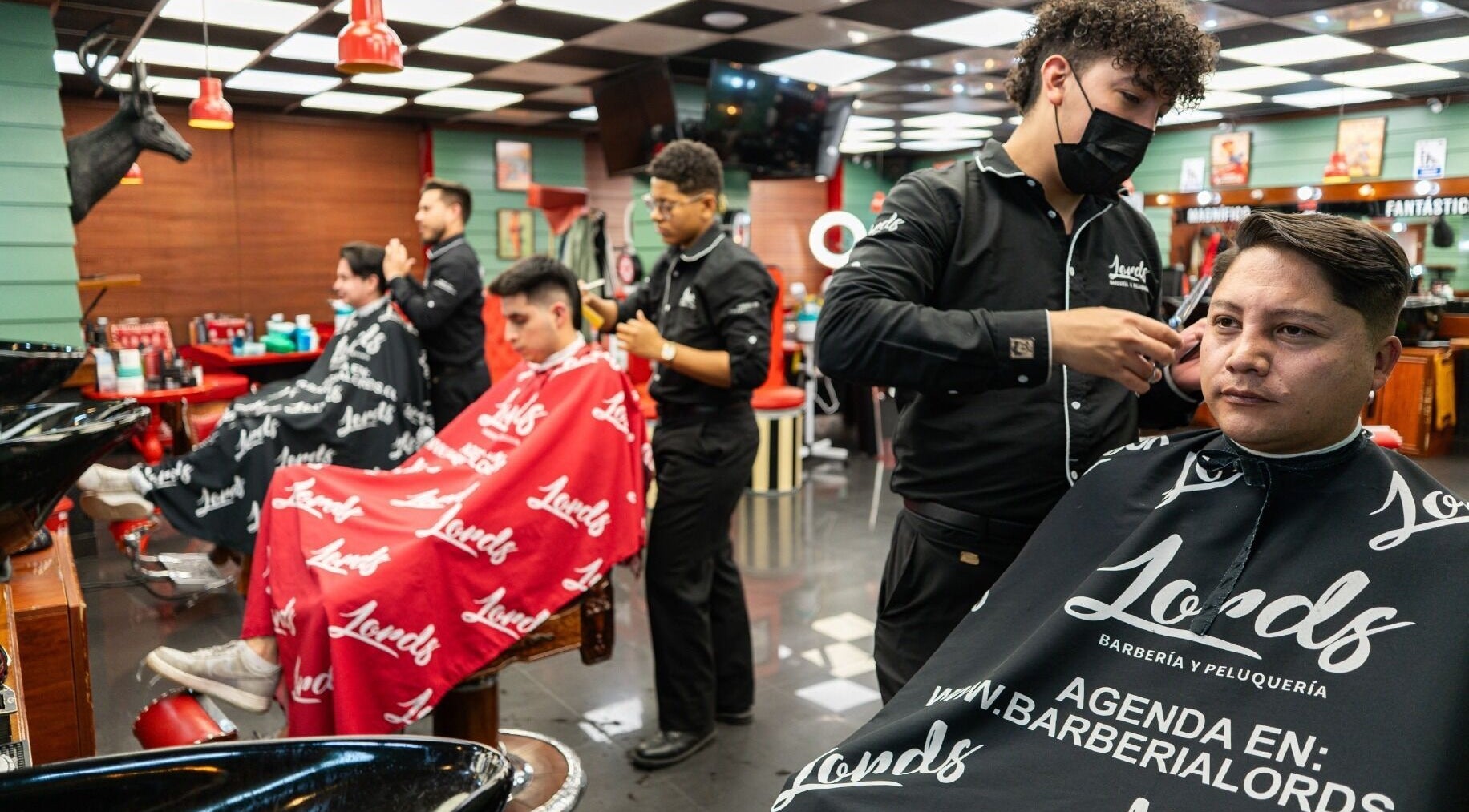 Servicio de barbero en Barberia Lords Sucursal Country Club, Bogotá, Bogotá, CO. Clientes relajados recibiendo cortes.